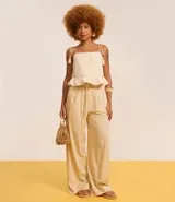 Pantalón de corte amplio tipo pantalona, confeccionado en mezcla de viscosa y lino. Presenta cintura con trabillas, pliegues frontales y un cinturón de cuerda ajustable con hebilla decorativa y esferas en los extremos.