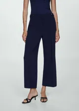 Pantalon de vestir azul marino con diseño recto y corte crop. Presenta tiro medio, cierre frontal con cremallera y botones decorativos en la cintura.