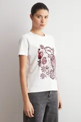 Remera blanca de manga corta con estampado frontal de diseño damasco floral en tonos bordó y marrón.