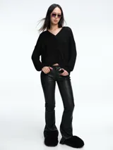 Cardigan de punto con hilo brillante, cuello en V y cierre frontal con botones. Presenta mangas largas con puños acanalados y un diseño de calce holgado.