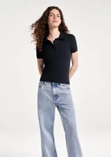 Remera polo de manga corta, color blanco, de corte ajustado con cuello camisero y cartera de tres botones frontales.
