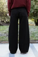 Jean de tiro alto con corte wide leg, confeccionado en denim negro. Presenta un calce relajado, pierna amplia y bolsillos funcionales.