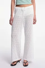 Pantalón blanco de tejido calado con diseño de rombos, cintura elástica con cordón ajustable y ruedo con terminación ondulada.