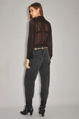 Jean de corte barrel, color negro, con diseño de pierna curva y holgada. Presenta cierre frontal con botón y bolsillos laterales.