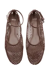 Zapato plano estilo Mary Jane color marrón, confeccionado con tejido de malla tipo red con diseño de rejilla. Cuenta con punta redondeada, suela plana y tira ajustable con hebilla metálica en el tobillo.