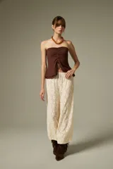 Pantalón tipo babucha de encaje color crudo, con corte holgado y cintura elástica.