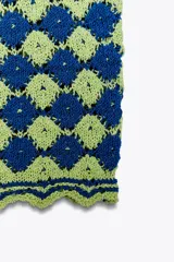 Top corto tejido a crochet, con escote recto y tirantes anchos.