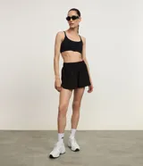 Bermuda deportiva Get Over modelo runner color beige, con cintura elástica, bajo redondeado y aberturas laterales. Cuenta con un pequeño bolsillo funcional trasero.