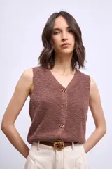 Chaleco de punto color marrón, con escote en V y cierre frontal con botones dorados.