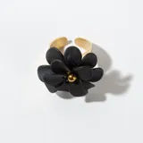Anillo dorado con aplique de flor negra con centro dorado.