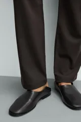 Mocasín negro de piel con parte superior lisa, horma ligeramente cuadrada y suela ultrafina.