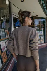 Chaqueta de punto de cuello redondo y manga larga, con cierre frontal de botones y acabados en rib.