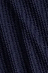 Malla enteriza de color azul marino con textura acanalada, tirantes finos blancos y ribete blanco en el escote.