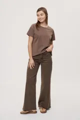 Pantalón jean de tiro medio, color negro, de corte amplio y silueta extra wide leg. Presenta diseño clásico de cinco bolsillos, cierre frontal con botón y cremallera, y detalle de tachas metálicas aplicadas a lo largo de los laterales.