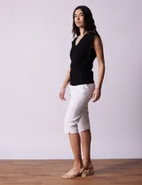 Buzo tejido en hilado fino color beige, con escote en V y sin mangas.