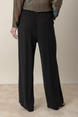 Pantalón ancho negro de lino y rayón, con cintura elastizada ajustable con cordón y bolsillos laterales.