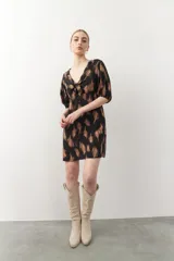 Vestido corto negro con estampado abstracto en tonos marrones, escote en V con lazo y mangas 3/4 con elástico.