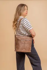 Bandolera mediana de cuero sintético color negro, con correa regulable, bolsillo frontal con cierre y compartimento principal.