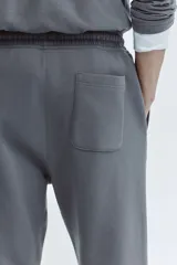 Pantalón deportivo de felpa con interior cepillado, corte relajado, cintura elástica con cordón de ajuste, bolsillos laterales y puños acanalados en los tobillos.