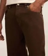 Pantalón baggy negro de sarga de algodón, con cintura fija con trabillas, botón contrastante y cierre por cremallera oculto, bolsillos laterales y traseros. Modelo holgado de corte recto y ancho.