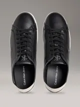 Zapatillas urbanas Calvin Klein de perfil bajo, color negro con suela blanca y detalle beige en el talón. Confeccionadas en cuero granulado, cuentan con cordones negros y el monograma de la marca grabado en el lateral.
