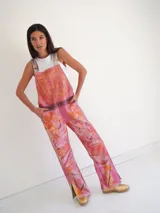 Jardineros de cuero con estampado artístico en tonos fucsia, naranja y rosa.