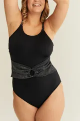 Malla entera negra con escote redondo y breteles finos regulables. Presenta un cinto ancho en lycra lurex plateada con detalle de aro metálico.