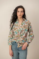 Camisa de manga larga con estampado floral multicolor, cuello camisero y cierre frontal de botones.