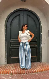 Jean estilo wide leg con diseño rayado en color celeste y blanco, de tiro alto y corte ancho en las piernas.
