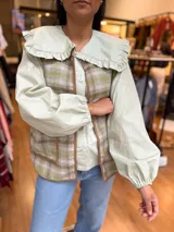 Camisa verde menta con amplio cuello marinero con volados, mangas largas y abotonadura frontal con botones nacarados.