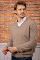 Sweater de punto con escote en V y mangas largas, confeccionado en tejido suave de color beige.
