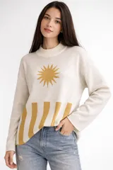 Sweater de tejido de punto en color crudo, con diseño jacquard que presenta un sol en la parte superior y franjas verticales en la parte inferior en color mostaza. Posee cuello redondo y corte holgado.