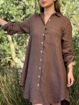 Vestido camisero color beige claro, de lino 100% natural, con botones de nácar, bolsillo delantero y mangas 3/4 con botón para recogerlas. Diseño asimétrico, más largo en la parte trasera.