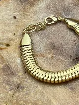 Pulsera dorada ancha con eslabones rectangulares.