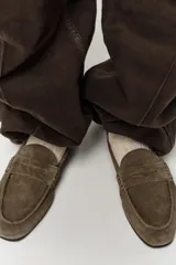 Mocasín de mujer confeccionado en serraje, con diseño de antifaz en el empeine y punta redonda. Presenta una suela plana de 2 cm.