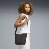 Bolso tipo bucket de la marca Puma, color negro con textura arrugada y logo metálico dorado en la parte frontal. Cuenta con correa ajustable para el hombro y cierre superior.