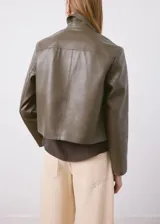 Chaqueta de cuero sintético color verde militar, con solapas clásicas, cierre frontal de botones y bolsillos laterales de parche.