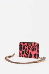 Billetera de tamaño mediano confeccionada en nylon, con cierre de cremallera y tirador de cordón. Presenta estampado animal print en tonos fucsia y negro, con logo metálico dorado en el frente.