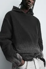 Jersey de punto de algodón con corte relajado, cuello redondo y manga larga. Presenta un diseño con estampado efecto spray degradado y acabados en rib.
