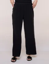 Pantalón pull-on de color beige con caída fluida, cintura elastizada fruncida, bolsillos laterales funcionales y pierna amplia de corte wide leg.