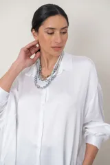 Conjunto de collar y aros compuesto por un collar de perlas de múltiples hilos en degradé de grises con detalles de piedras facetadas, y caravanas con perlas colgantes.