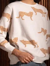 Buzo de punto con cuello redondo, manga larga y estampado de tigres en color tostado sobre base blanca.