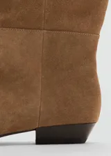 Bota de caña alta confeccionada en piel de serraje color marrón, con diseño flat, punta cuadrada y sin cierre.