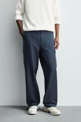 Pantalón cargo de corte regular fit, confeccionado en tejido ligero de algodón. Presenta bolsillos laterales tipo cargo con solapa, bolsillos frontales y bolsillos traseros de vivo. Cierre frontal con cremallera y botón.