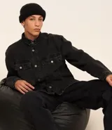 Camisa masculina de denim de algodón con efecto marmolado, corte oversized tipo boxy, cuello camisero, mangas largas, cierre frontal con botones y dos bolsillos frontales con solapa en el pecho.