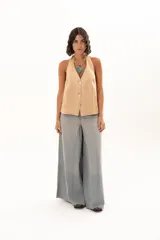 Pantalón de jean tiro alto con diseño de pierna extra ancha y caída fluida. Presenta costuras verticales que realzan su estructura, bolsillos funcionales y terminación de ruedo deshilachado.