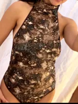 Body reversible de cuello alto y espalda descubierta, confeccionado con tejido de lycra elastizada de calce entallado, con un estampado abstracto en tonos oscuros y marrones.