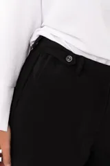 Pantalon de vestir negro de corte recto y tiro alto, con bolsillos laterales y cierre frontal con cremallera y boton.