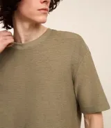 Remera color crema, de corte holgado, con cuello redondo y mangas cortas.