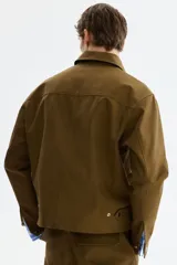 Sobrecamisa boxy de algodón, color verde militar, con cuello inglés, tapeta con botones a presión y bolsillos superiores con solapa.